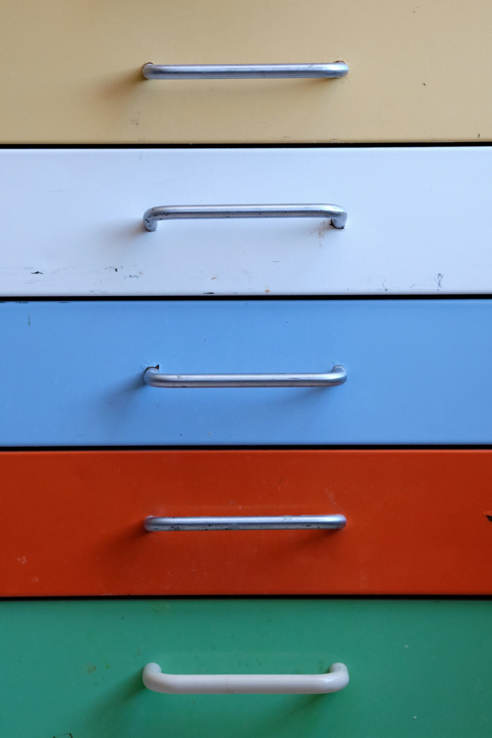 Cajones coloridos de mueble vintage con jaladores metálicos